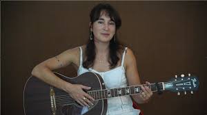 Michelle Shocked met gitaar en lang haar